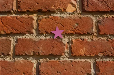 Aged Red Brick Wall with Magenta Star
