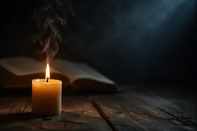 Single Candle with Smoke in Darkness