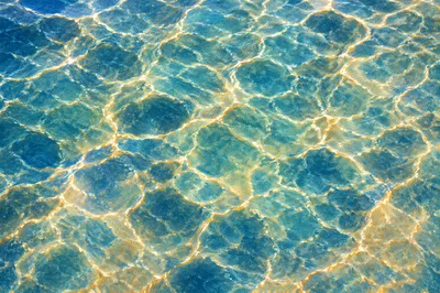 Golden Reflections on Flowing Turquoise Water