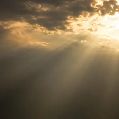 Golden Light Rays Through Misty Clouds