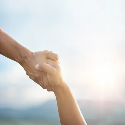Supportive Hands in Hopeful Sunlight Background