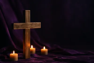 Wooden Cross with Candles on Purple Cloth