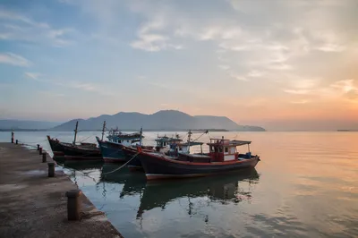 Calming Dawn Waterfront With Moored Fishing Boats