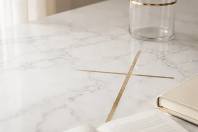 White Marble Surface with Gold Cross Accent