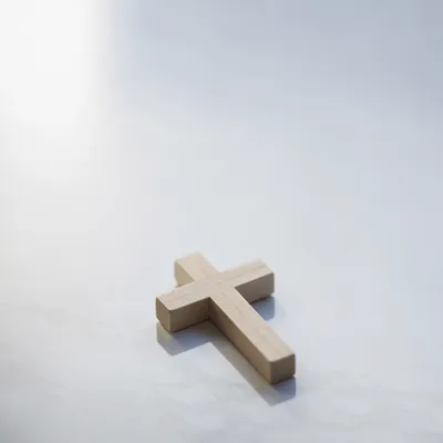 Minimal Wooden Cross on Glossy Blue Background