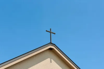 Minimal Cross Above Beige Church Roof