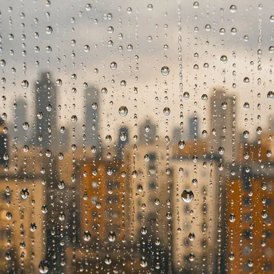 Rain Droplets Over Blurred Urban Skyline
