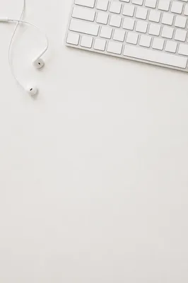 Minimal White Desktop With Keyboard and Earbuds