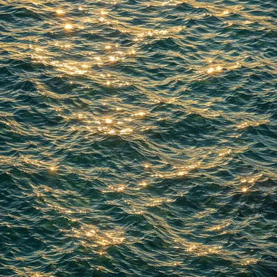 Turquoise Ocean Ripples with Golden Sunlight