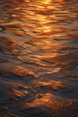 Golden Sunset Reflection on Rippled Beach Sand
