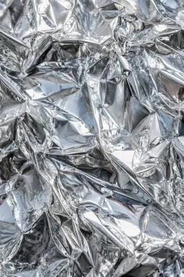 Crumpled Silver Foil Reflective Texture Background