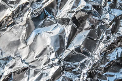 Crumpled Silver Foil Reflective Texture Background