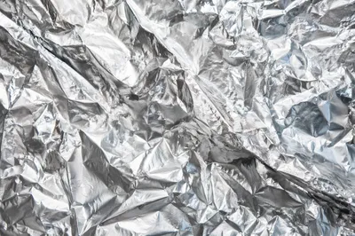 Crumpled Silver Foil Reflective Texture Background