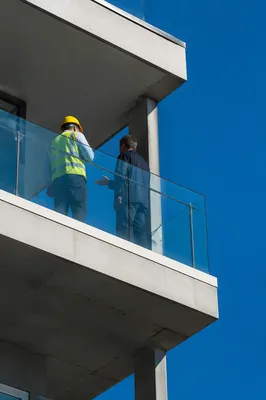 Construction Workers Discuss Project on Balcony