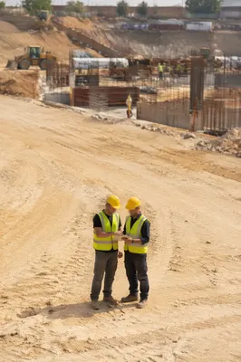 Construction Workers Reviewing Plans on Site