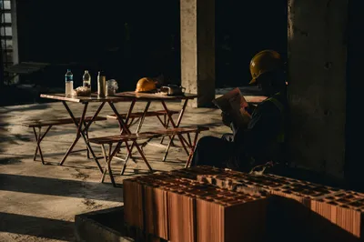 Construction Worker Reading During Quiet Site Break