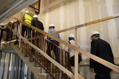 Construction Inspectors Walking Through Unfinished Stairwell