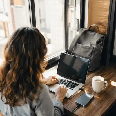 Freelancer Working in Sunlit Coworking Cafe