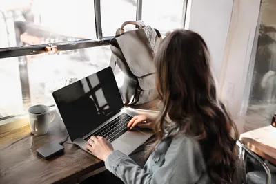 Freelancer Working in Sunlit Coworking Cafe