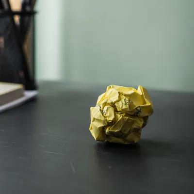 Crumpled Yellow Note on Office Desk