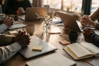Startup Team Prayer Around Morning Worktable