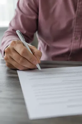 Hand Signing Business Contract on Desk