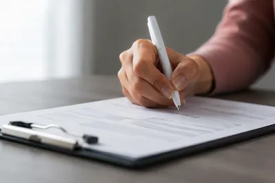Hand Signing Business Contract on Desk
