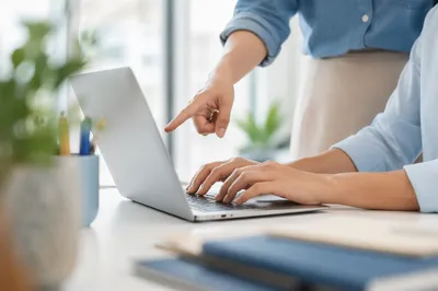 Hands Discussing Laptop in Modern Office