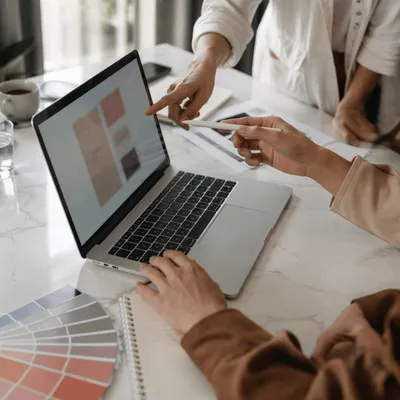 Team Hands Pointing at Laptop Screen
