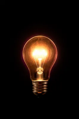 Glowing Lightbulb Business Idea on Dark Background