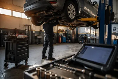 Mechanic Working Under Car in Repair Shop
