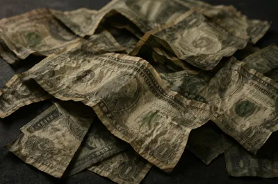 Crumpled Dollar Bills on Dark Tabletop
