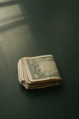 Folded Dollar Bills on Green Table
