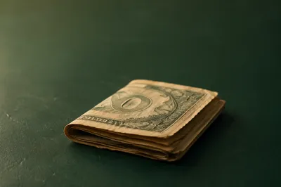 Folded Dollar Bills on Green Tabletop
