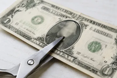 Scissors Cutting Dollar Bill Close Up