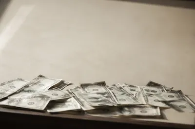 Scattered Cash on Warm Cream Tabletop