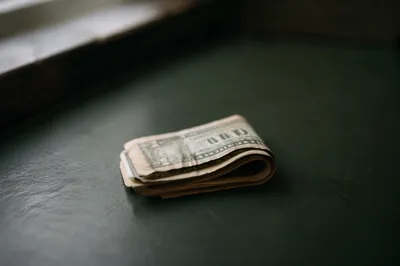 Folded Dollar Bills on Green Tabletop