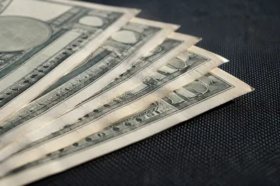 Fanned Dollar Bills on Charcoal Fabric