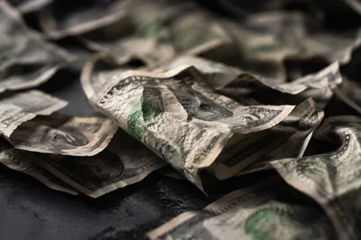 Crumpled Dollar Bills on Dark Tabletop