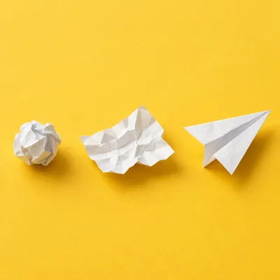 Paper Airplane Idea Evolution on Yellow Desk