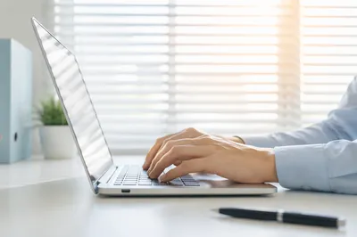 Professional Writing Email on Laptop Desk