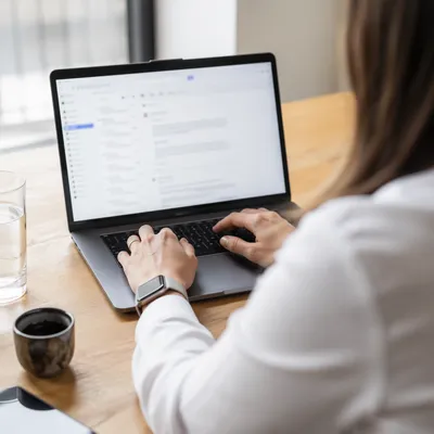 Professional Writing Email on Laptop Desk