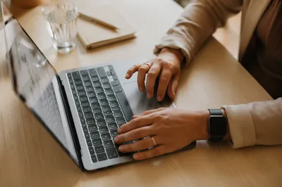 Professional Hands Writing Email on Laptop