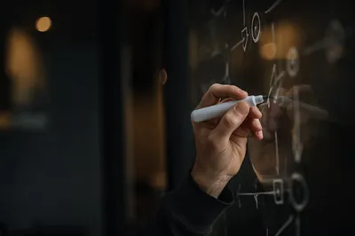 Hands Writing Strategy on Glass Board