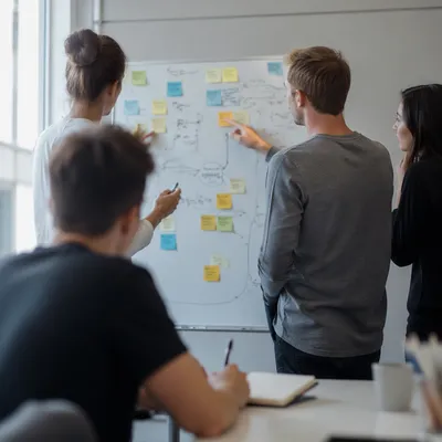 Modern Team Brainstorm Around Conference Whiteboard