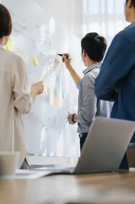 Team Brainstorm at Whiteboard in Conference Room