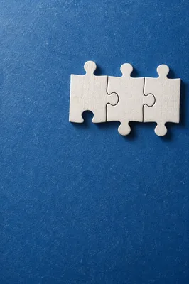 White Puzzle Pieces on Blue Teamwork Background