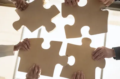 Teamwork Puzzle Pieces Joining in Office