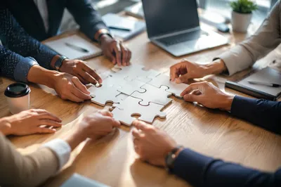 Hands Assembling Puzzle for Teamwork Success