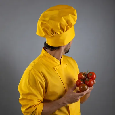 Chef Holding Fresh Tomatoes in Yellow Uniform